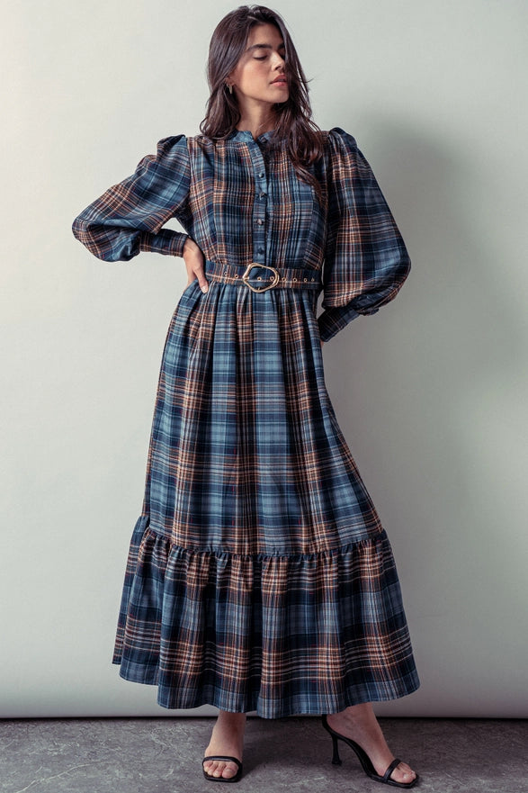 Woman wearing a blue plaid maxi dress against a plain background.