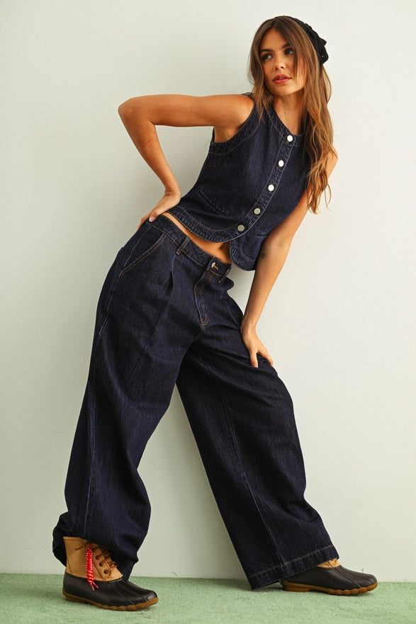 Woman wearing a navy blue denim outfit with a white background