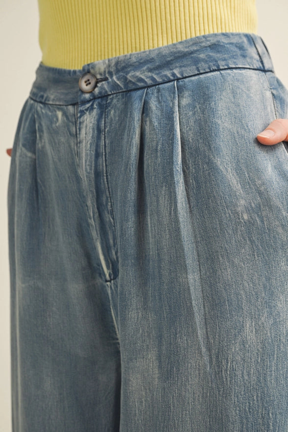 Close-up of blue denim pants with a beige background