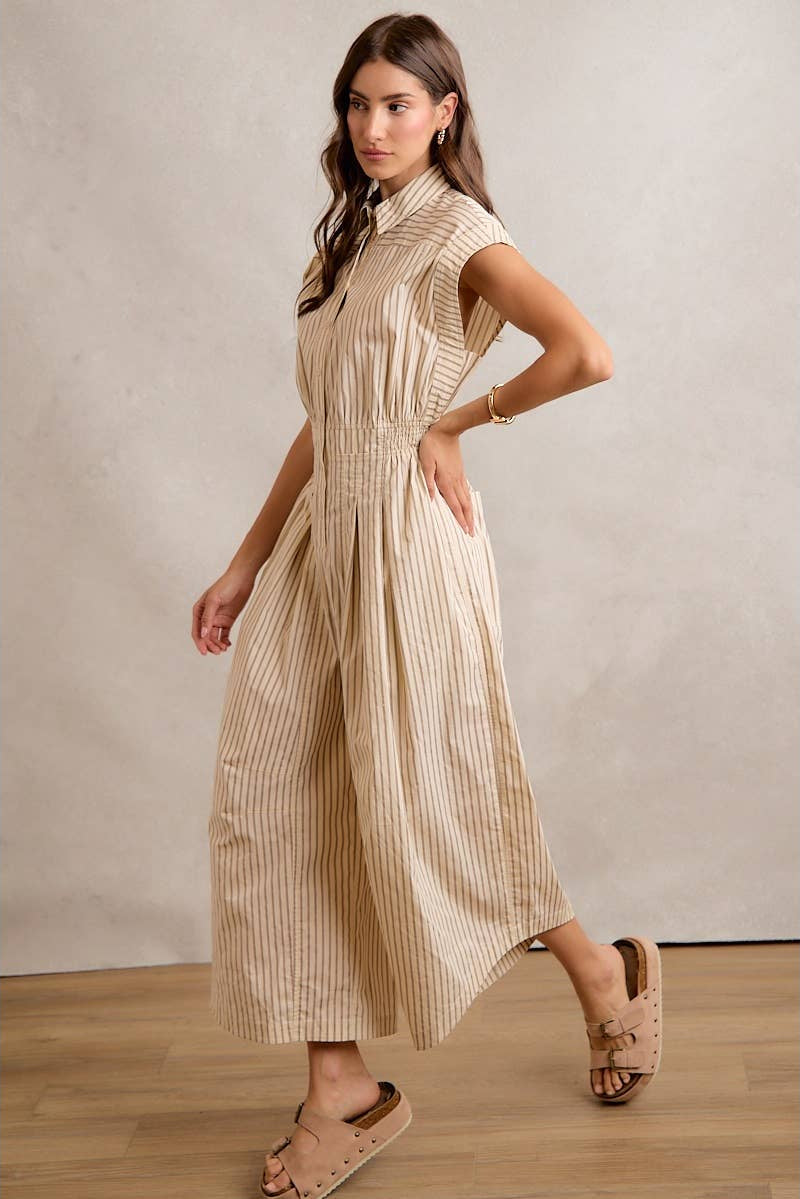 Woman wearing a beige striped dress against a plain background