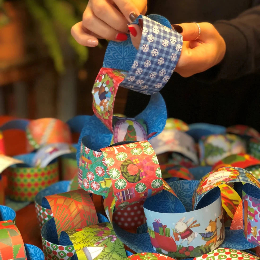 Colorful paper bracelets being held by a person with a blurred background