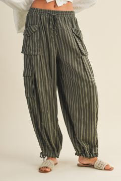 Person wearing olive colored striped cargo pants on a plain background.