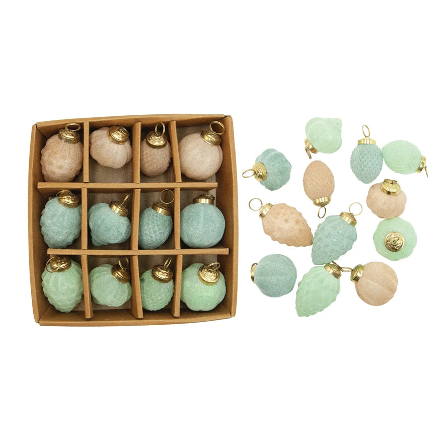 Set of decorative ornaments in a box with additional ornaments displayed on a white background